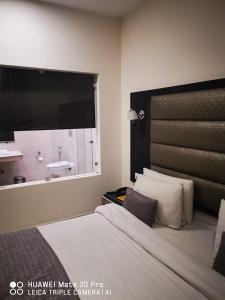 Schlafzimmer mit einem Bett und einem Fenster mit einem Waschbecken in der Unterkunft Hotel PK Residency in Noida