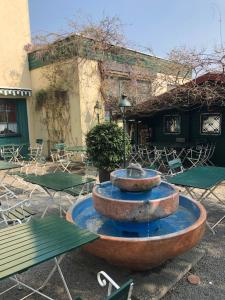 una fontana di fronte a un edificio con tavoli e sedie di Hotel Pflieger a Pocking