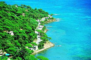 a winding road on a hill next to the ocean at Hôtel Lou Paouvadou in Sainte-Maxime