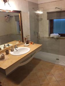bagno con lavandino, specchio e doccia di Ohana ad Acquaviva delle Fonti