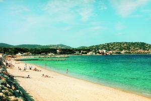 a group of people on a beach in the water at Hôtel Lou Paouvadou in Sainte-Maxime