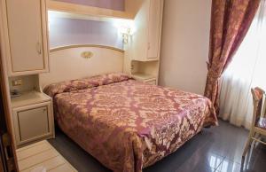 a small bedroom with a bed and a window at Hotel La Meridiana in Anghiari