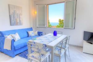ein Wohnzimmer mit einem blauen Sofa und einem Tisch in der Unterkunft Ü Maxeu- Maestrale in Cervo