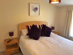 a bedroom with a white bed with pillows on it at Seafront House, Westward Ho! in Westward Ho