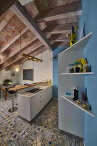 a kitchen with white cabinets and a blue wall at Attico da Maria in Polpenazze del Garda