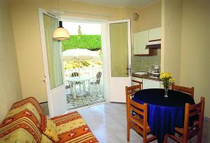 a living room with a table and a kitchen at Hôtel Lou Paouvadou in Sainte-Maxime