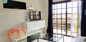 a living room with a table and a large window at Balcon Del Mar Luxury Suite in Costa Del Silencio