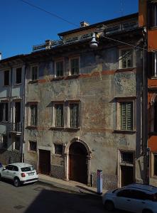 ein altes Gebäude mit einem davor geparkt in der Unterkunft Palazzo Cavalli Pasquini in Verona