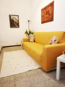 a yellow couch in a living room with a rug at Tenente Amendola 2 in Lipari