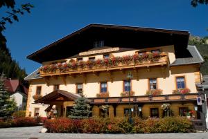 ein großes Gebäude mit Blumenkästen darauf in der Unterkunft Hotel 3 Gemsen in Mallnitz