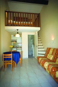 a living room with a table and a staircase at Hôtel Lou Paouvadou in Sainte-Maxime