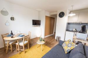 a living room with a couch and a table and a kitchen at Appartement T2 - Proche Gare - Bord de Vilaine in Rennes