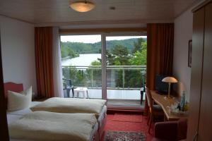 a hotel room with two beds and a large window at Seehotel Andree & Gästehaus Seehof in Waldeck