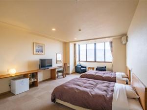 a hotel room with two beds and a television at HAKONE GORA ONSEN Hotel Kasansui in Hakone