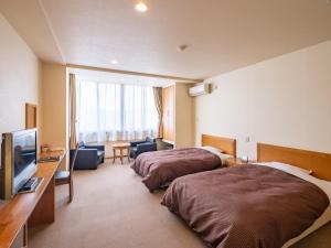 a hotel room with two beds and a television at HAKONE GORA ONSEN Hotel Kasansui in Hakone