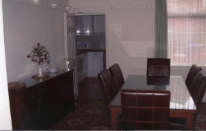 a living room with a table and chairs and a kitchen at Spa Holiday Apartments in Bridlington