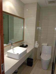 a bathroom with a white sink and a toilet at Dunhuang Dasheng Vacation Hotel in Dunhuang