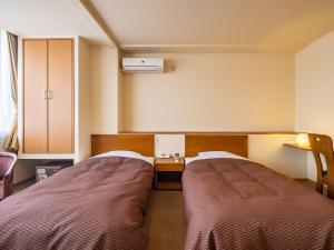 a room with two beds and a desk at HAKONE GORA ONSEN Hotel Kasansui in Hakone