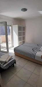 a bedroom with a bed and a chair in it at Apartments Nika's View in Vodice