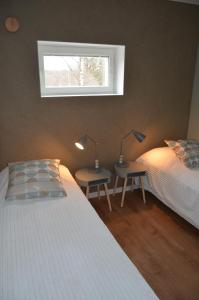 een slaapkamer met 2 bedden en 2 lampen op tafels bij Tammiston Apartments in Naantali