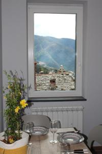 un tavolo con finestra affacciata su una montagna di Residenza del Capitano Luxury Apartments a Levanto Altre 5 foto