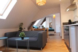 een woonkamer met een bank en een tafel bij Résidence MILA in Valenciennes