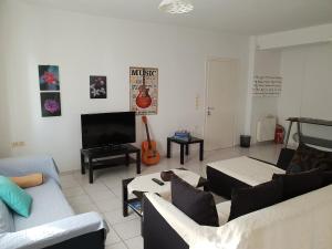uma sala de estar com sofás e uma televisão de ecrã plano em Spacious Apartment with large Balcony em Heraclião