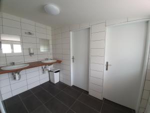 ein Badezimmer mit zwei Waschbecken und zwei Spiegeln in der Unterkunft Olivin Kytlice Hiker Huts in Kytlice