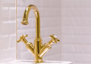 a gold faucet on a sink in a bathroom at Araf Hotel in Konya