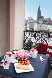 a table with a plate of food and bowls of food at Le Kléber Hôtel in Strasbourg