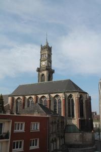 een gebouw met daarop een klokkentoren bij Résidence MILA in Valenciennes