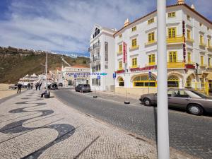 a street with cars parked on the side of a building at Apartamento Solymar in Nazaré