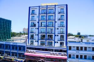 a tall white building with a sign on top of it at Sheratton Regency Hotel in Mombasa