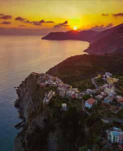 an aerial view of a village on a cliff with the sunset at I TRE GRAPPOLI in Corniglia