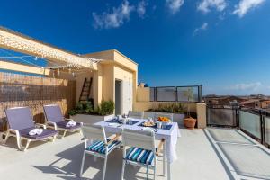 a patio with a table and chairs on a balcony at Maison Brigitte - Solemar Sicilia in Santa Flavia