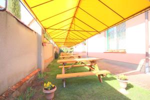 a group of picnic tables under a yellow roof at Willa Ewa in Jantar