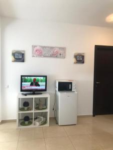 a flat screen tv sitting on top of a white cabinet at Studio Summerland in Mamaia