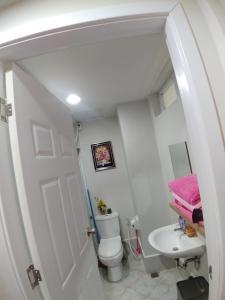 a small bathroom with a toilet and a sink at Lelani's Comfy Condo in Mactan