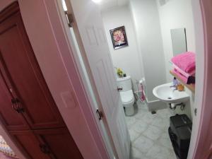 y baño con aseo y lavamanos. en Lelani's Comfy Condo en Isla de Mactán