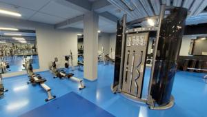 a gym with rows of exercise equipment on a blue floor at Hotel Jakuszyce Sport & Spa in Szklarska Poręba