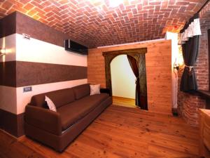 uma sala de estar com um sofá e uma parede de tijolos em Albergo Nazionale em Vernante