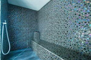 a bathroom with a shower with a mosaic wall at Hotel Lava Beach in Puerto del Carmen