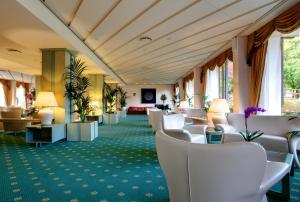 una sala de espera en un hotel con sillas blancas en Grand Hotel Presolana, en Castione della Presolana