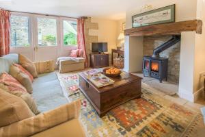 sala de estar con sofá y estufa de leña en West Cottage, Southlands Farm, Gunnerton, en Hexham