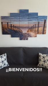 Apartamento Arosa Playa في كاليبي: جدار فيه صورة شاطئ ورصيف