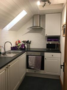 a kitchen with a sink and a stove top oven at Drum Brae Cottage in Edinburgh