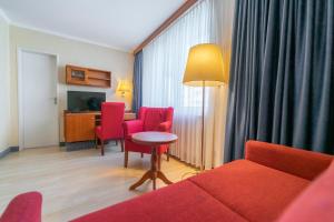 ein Wohnzimmer mit einem Sofa, einem Tisch und Stühlen in der Unterkunft Hotel Carmen in München