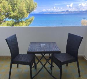 a table and chairs with a view of the ocean at L'Isula Rossa in LʼÎle-Rousse