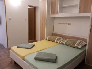 a bed in a room with two pillows on it at Apartments New Charming in Senj
