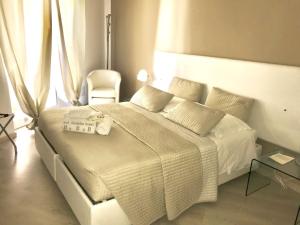 1 dormitorio con 1 cama blanca grande y 1 silla en casaTati, en Cagliari